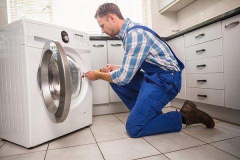 depositphotos_60927609-stock-photo-handyman-fixing-a-washing-machine